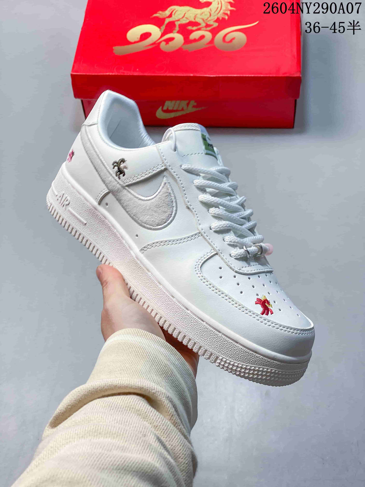 Side view of a white sneaker with an embroidered swoosh and decorative details