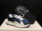 Angled view of one sneaker beside its outsole, showing the black tread pattern and white midsole.