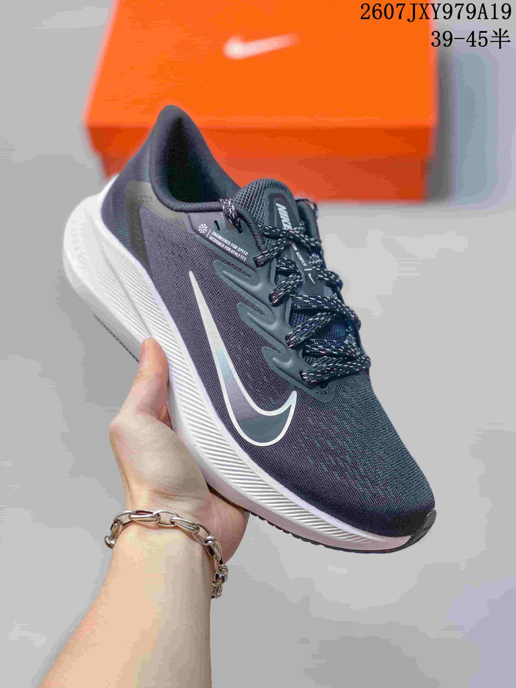 Angled side view of the dark gray and black running shoe with white midsole and white side logo.