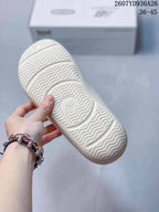 Close-up of the off-white sandal outsole showing a wavy traction pattern and a central New Balance logo.