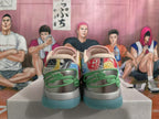 Rear view of multicolor Monopoly-themed Nike basketball shoes with green heel accents and teal outsole sections.