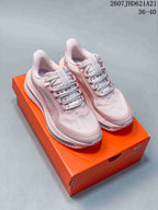 Pair of pink Nike Air Pegasus Premium sneakers displayed on an orange shoebox.