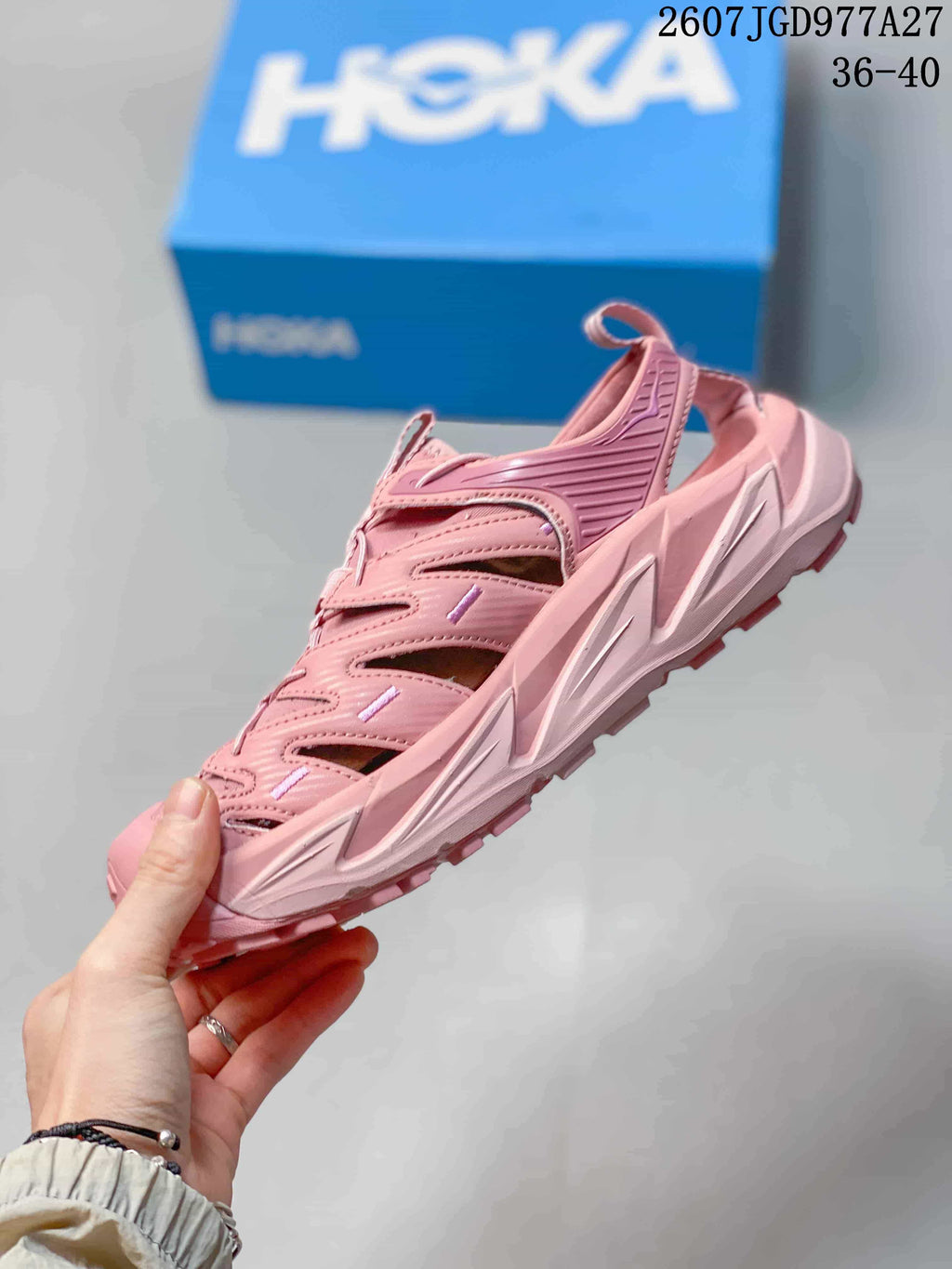 Side view of a pink HOKA sandal showing the closed toe, side cutouts, heel strap and sculpted sole; overlay shows size range 36–40.