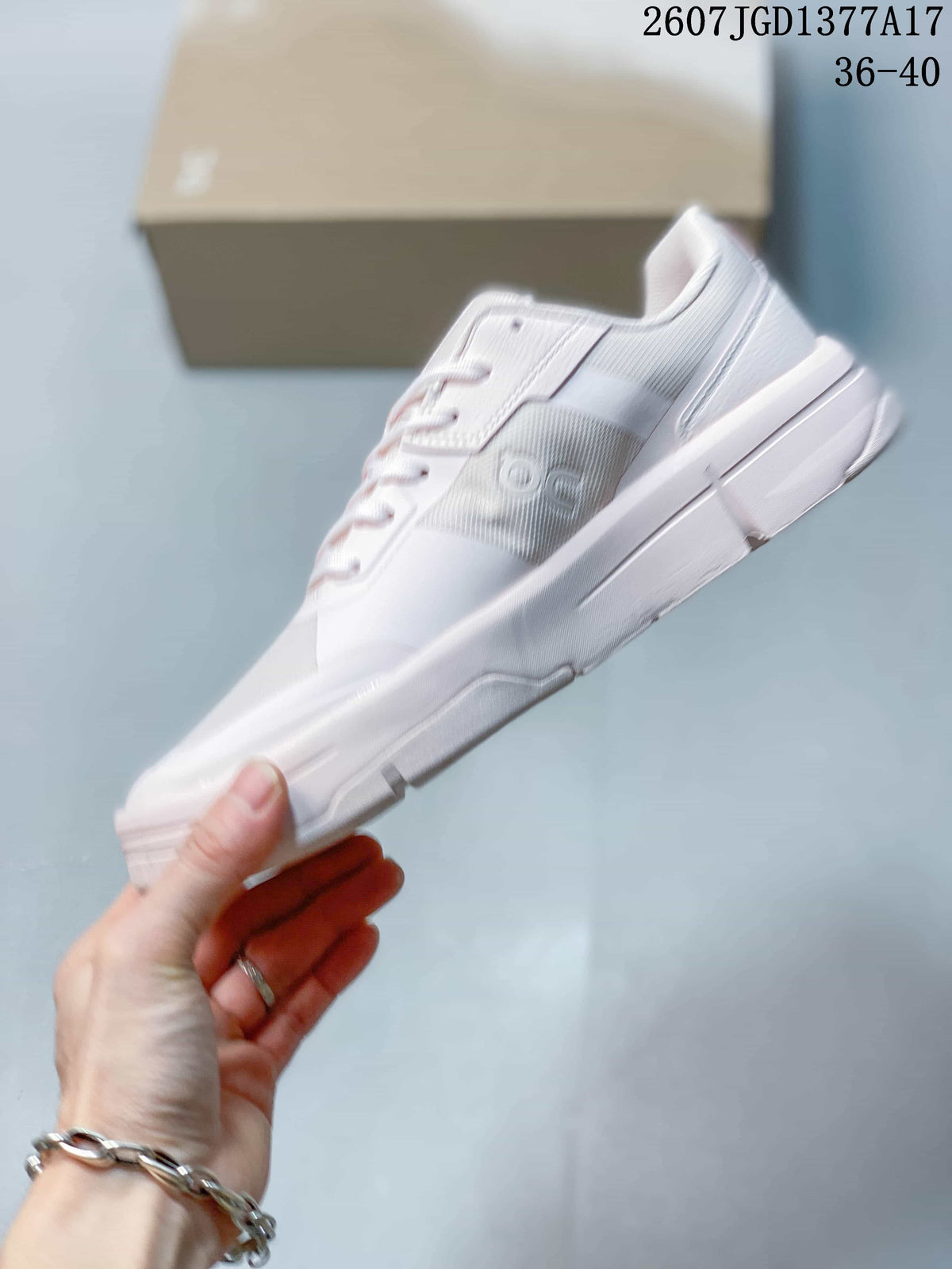 Side profile of the white and pale pink sneaker showing the low-profile shape, layered upper panels, and raised midsole.
