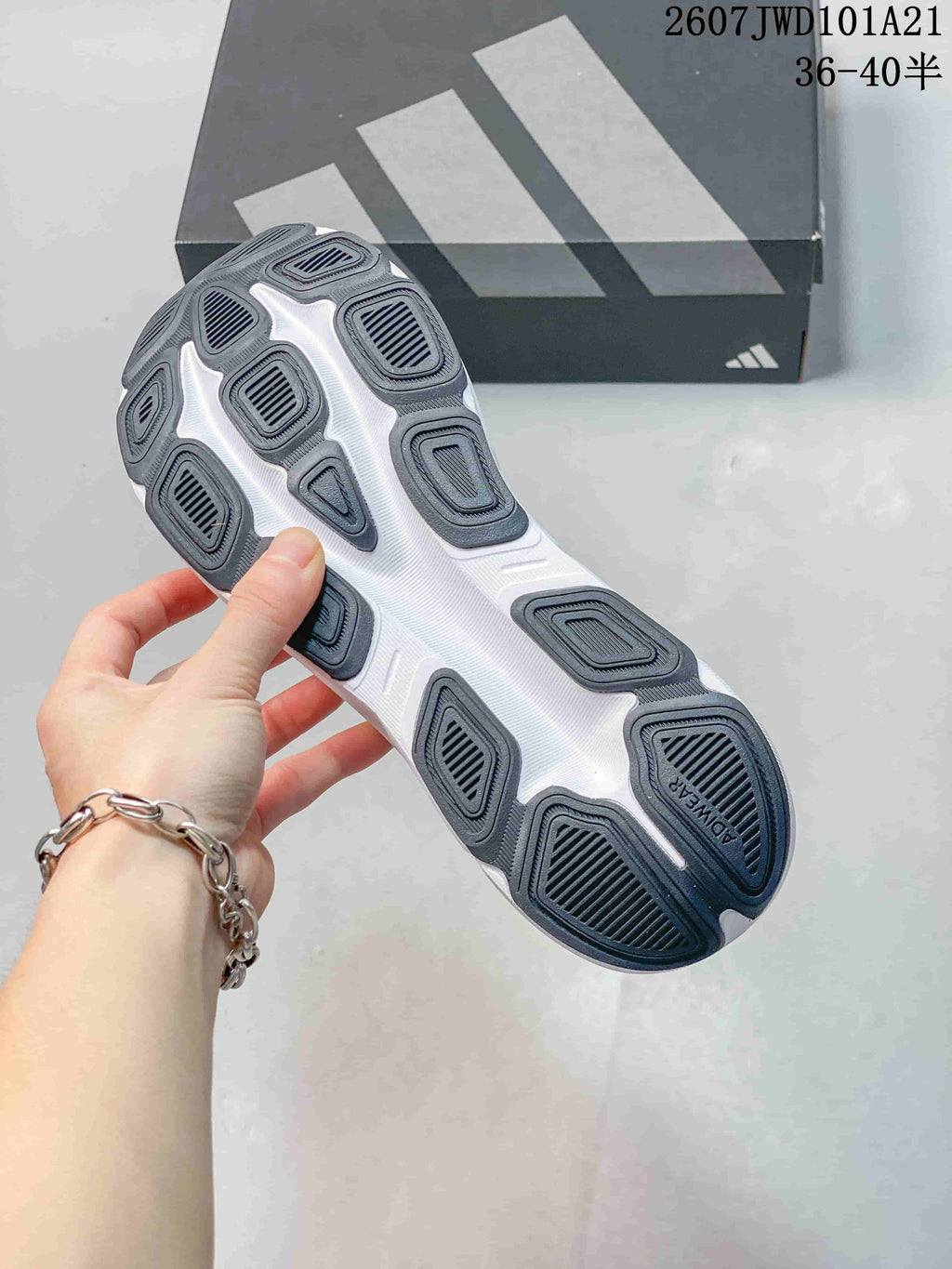 Close-up of the sneaker outsole showing multiple dark rubber traction sections and a white central sole area.
