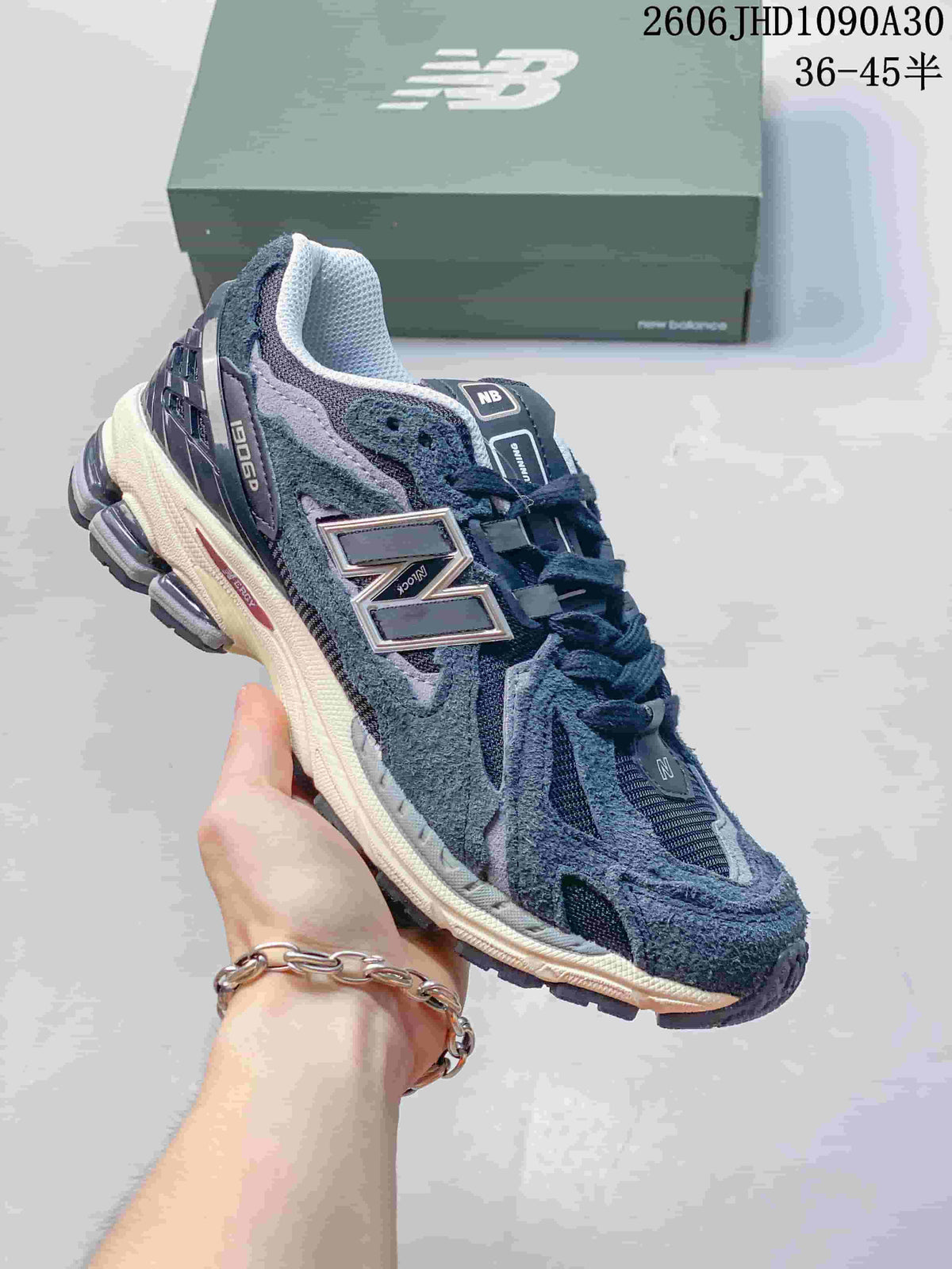 Dark navy and gray New Balance M1906R sneaker shown from the side