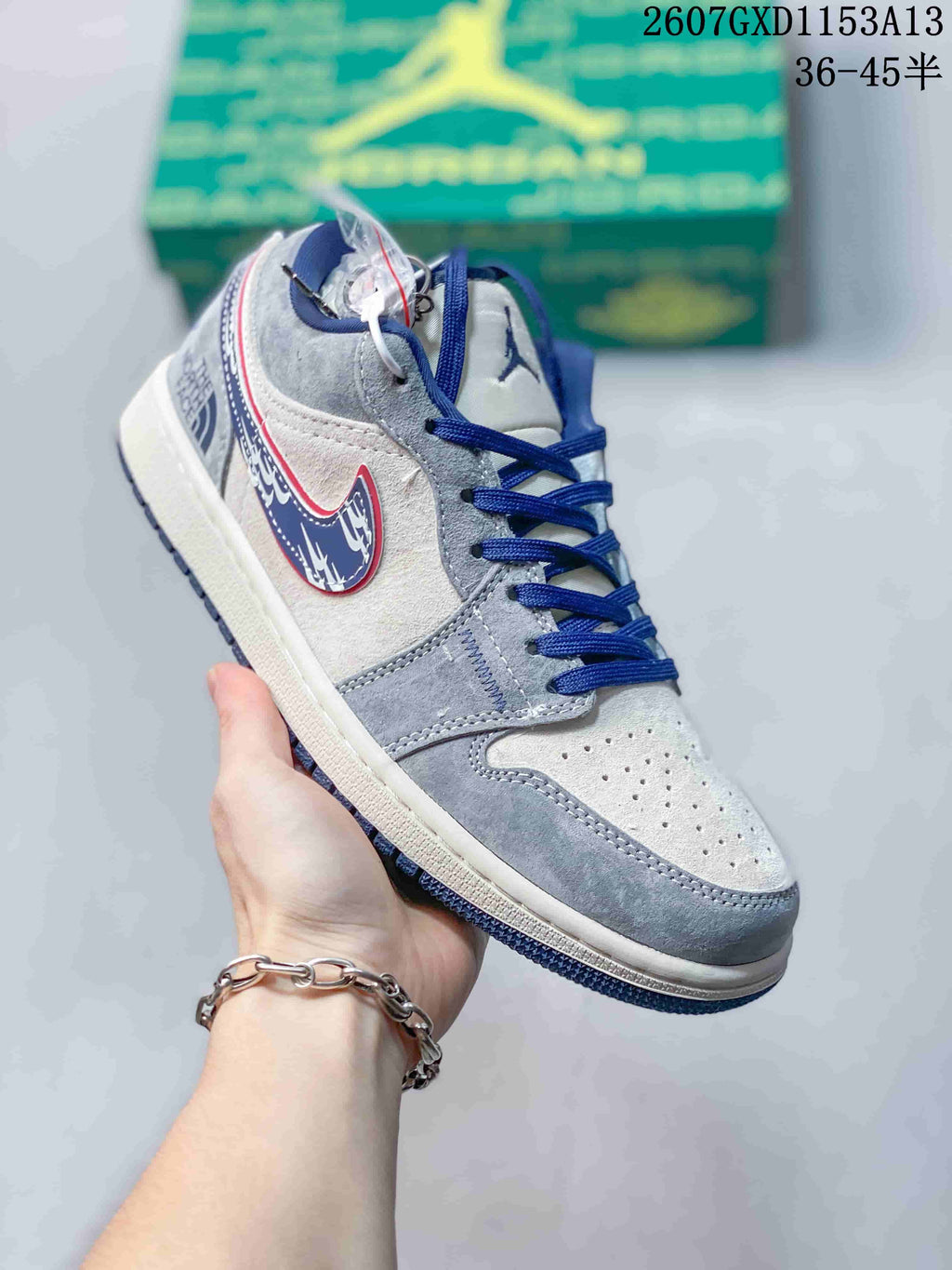 Angled side view showing the grey upper, blue laces, blue-and-red Swoosh and contrasting outsole.