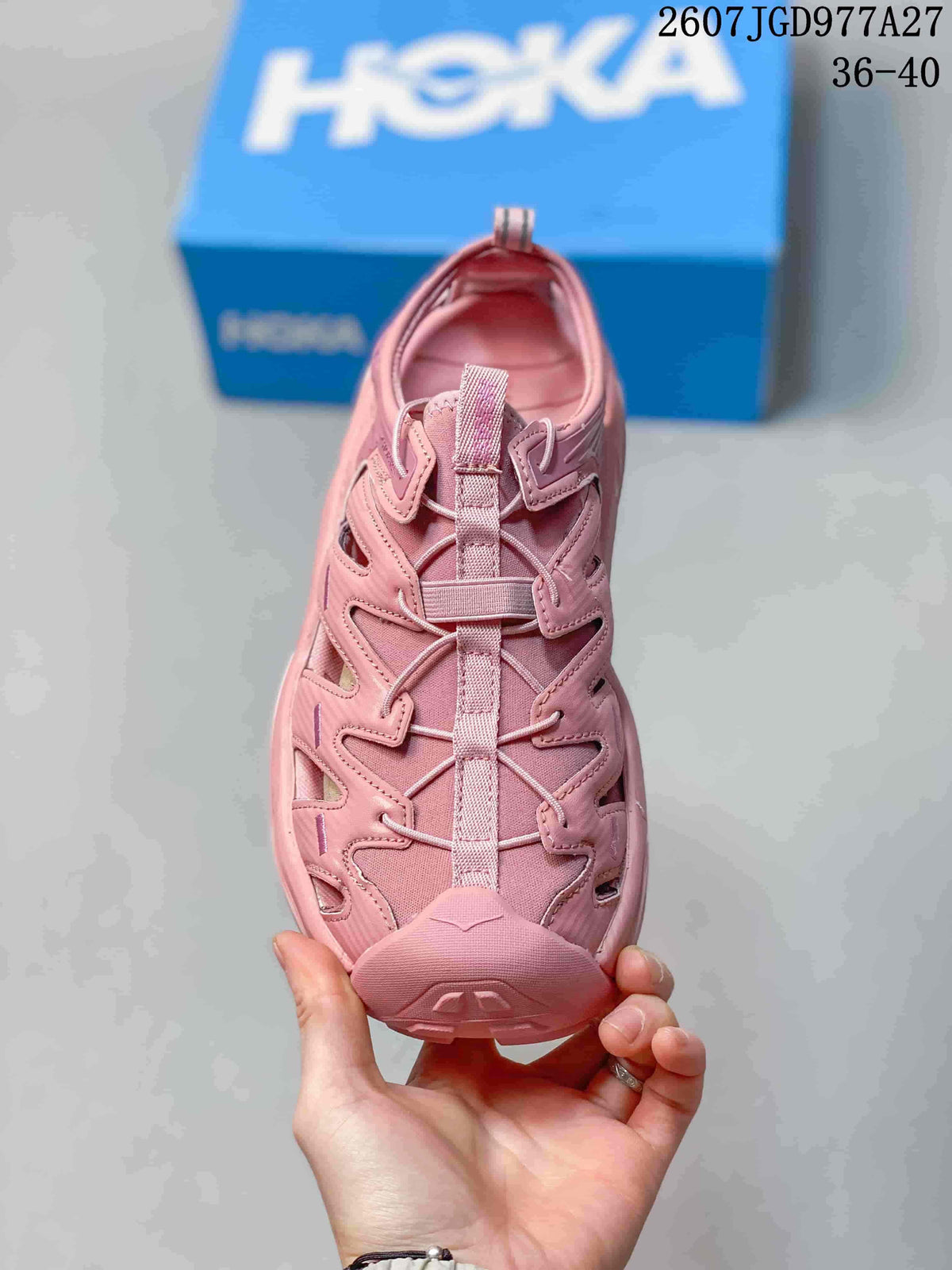 Top view of a pink HOKA sandal showing the lace and webbing closure, cutout panels and closed toe; overlay shows size range 36–40.