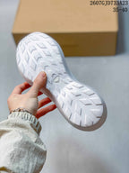 Close view of the white sneaker outsole showing directional geometric tread.