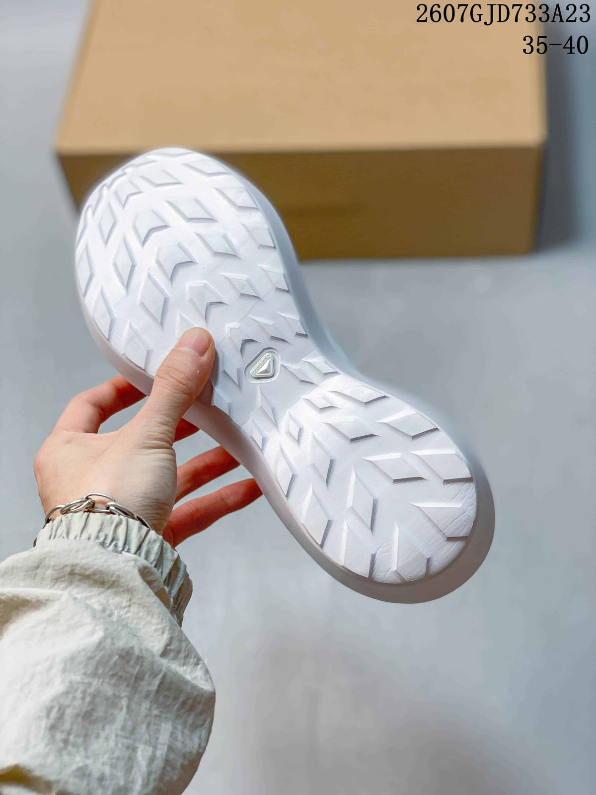 Close view of the white sneaker outsole showing directional geometric tread.
