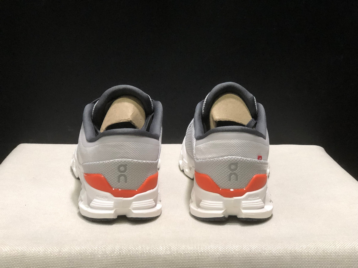 Rear view of the pair showing the padded collars, gray heel panels, orange accents, and On branding.