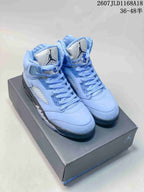 Pair of light blue Jordan Air Jordan 5 high-top sneakers displayed on a shoebox, with the style code and size range visible above.