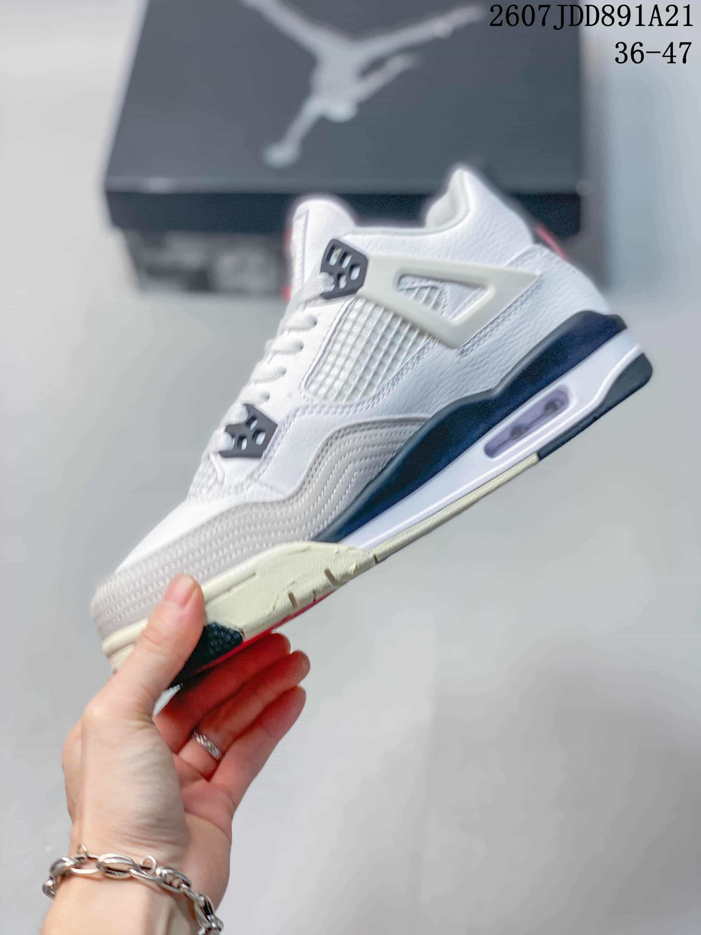 Side profile showing the white upper, mesh panel, molded support, visible cushioning window, and contrasting outsole.