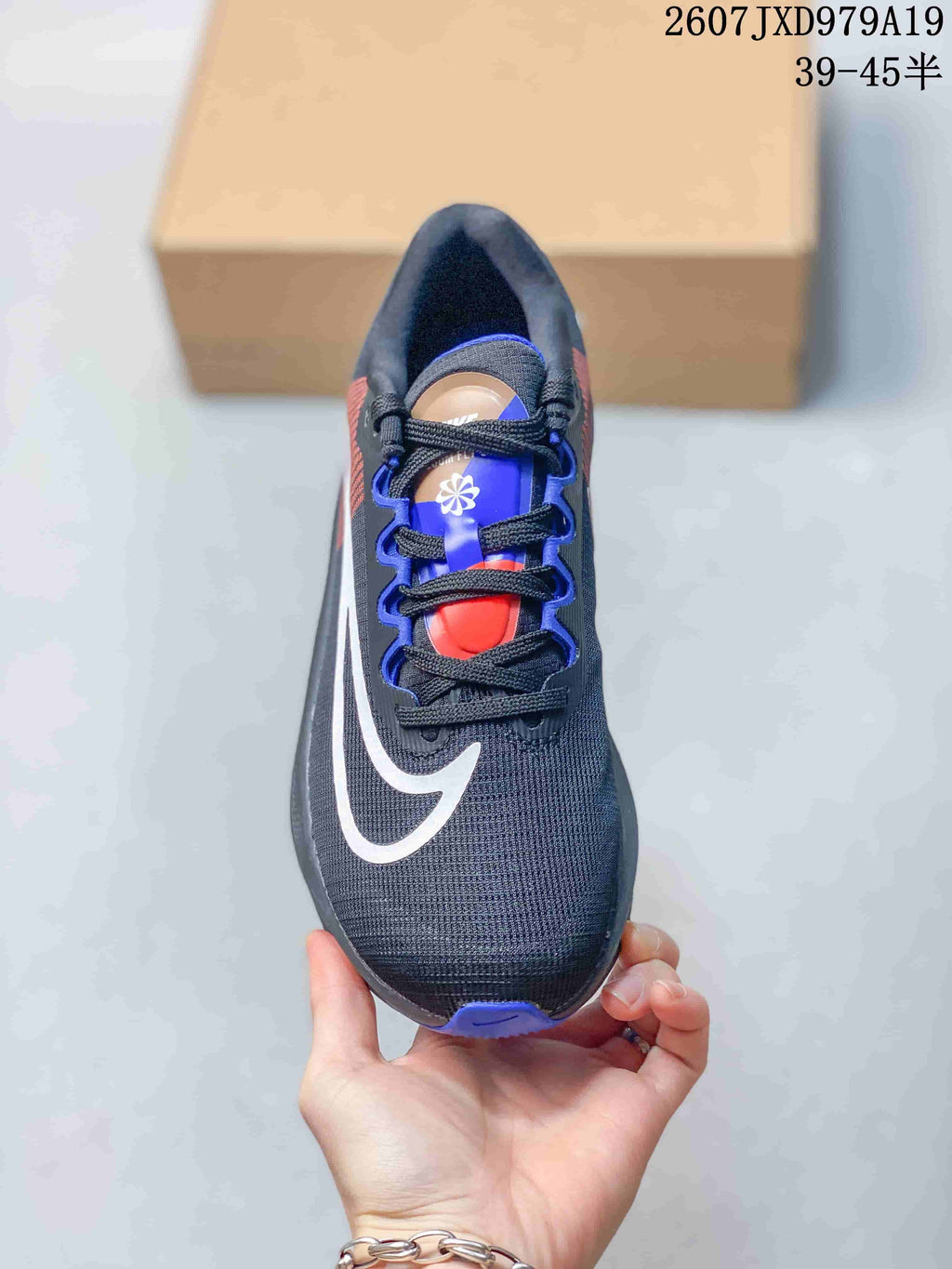 Top view of one shoe showing black laces, blue and red tongue details and a dark charcoal toe box.