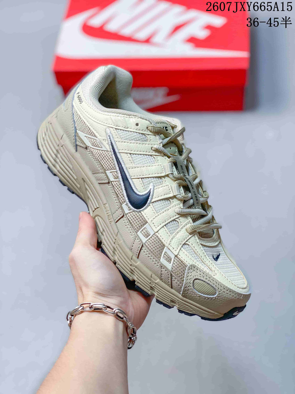 Angled side view showing the cream Nike P-6000 upper, navy Swoosh, overlays, and outsole.