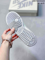 Underside view of a white sneaker showing the textured rubber outsole and circular traction pattern.