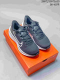 Pair of dark gray and white Nike Quest 6 running shoes displayed on an orange shoebox.