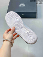 Underside of a white sneaker showing a textured outsole and circular traction patterns.