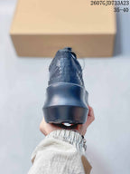 Rear view of the black sneaker showing the structured heel and thick sculpted sole.