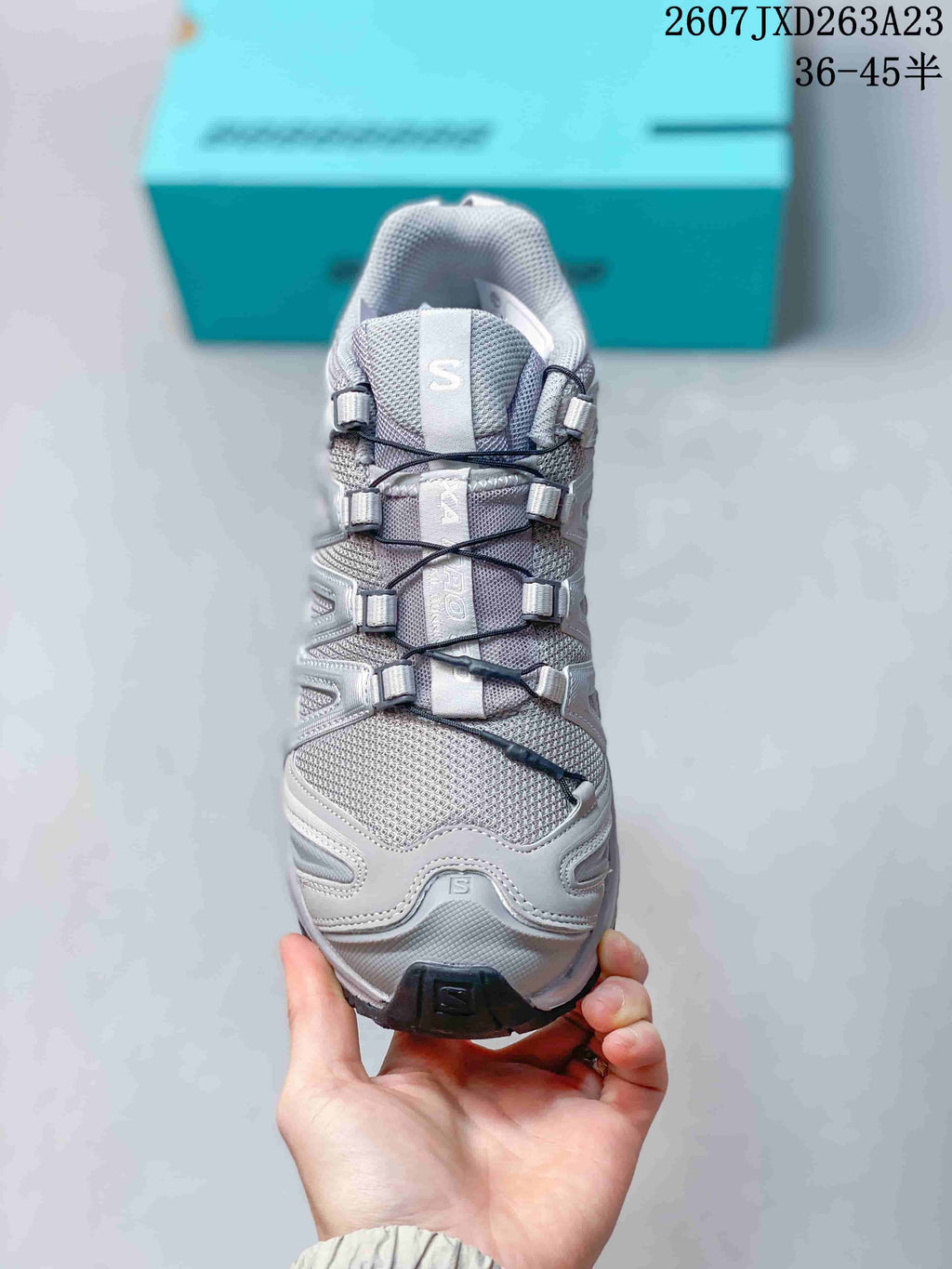Top-down view of the sneaker showing the mesh-like toe area, Salomon tongue branding, cord fastening system, and layered side panels.