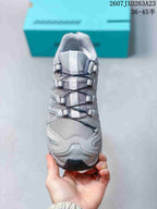 Top-down view of the sneaker showing the mesh-like toe area, Salomon tongue branding, cord fastening system, and layered side panels.