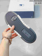 Underside of the sneaker showing a patterned dark outsole and white sidewalls.