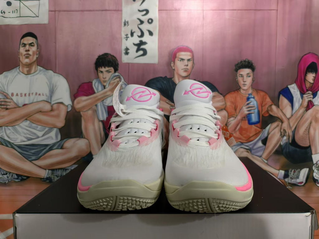 Front view of white basketball shoes with pink details and white laces