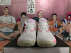Front view of white basketball shoes with pink details and white laces