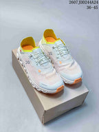 Pair of pale blue and white low-top lace-up sneakers with neon yellow-green lining and orange outsole accents displayed on a box.