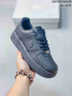 Close-up side view of a black low-top sneaker showing the swoosh, perforated toe, lace-up front and textured outsole.