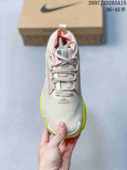 Top view of the low-top sneaker showing the lace-up construction, mesh-like toe area, pink lining, and contrasting neon yellow edges.