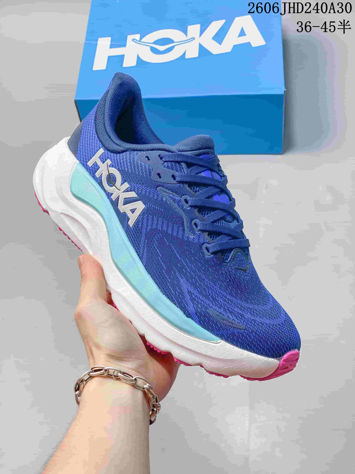 Side view of a blue HOKA running shoe with aqua and white midsole details