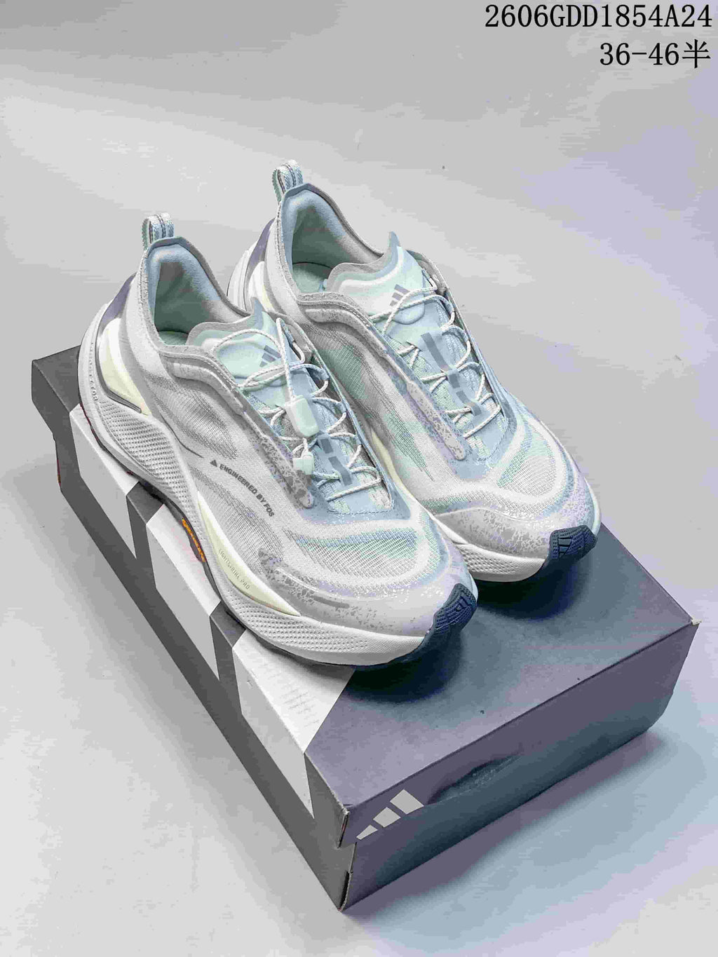 Pair of light gray and pale blue Adidas Holo Peak trail running shoes on a shoebox