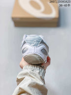 Rear view of the white sneaker showing the padded heel collar and circular outsole detail.