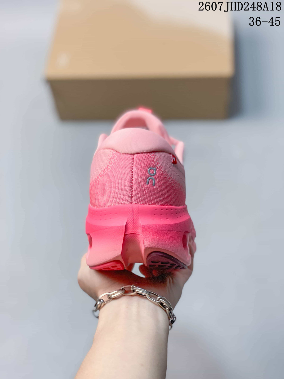 Rear view of the pink sneaker showing the padded collar, heel branding, and outsole structure.