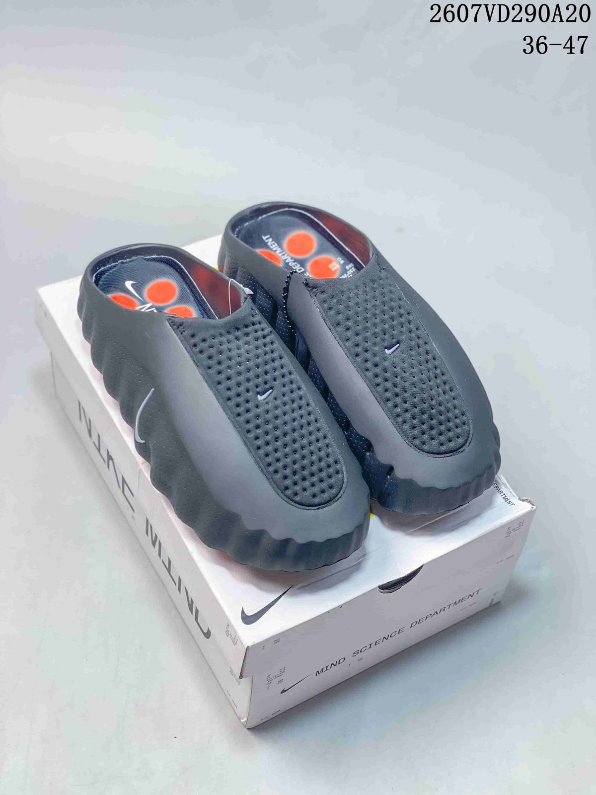 Pair of black and gray Nike Mind 001 slides displayed on a branded box; style code 2607VD290A20 and size range 36–47 are visible.