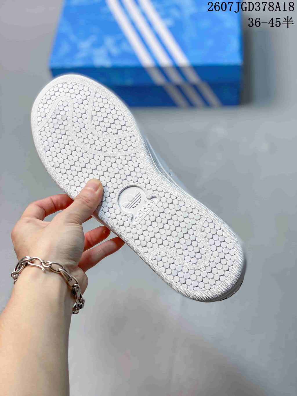 Close-up of the textured outsole showing circular traction details and Adidas branding.