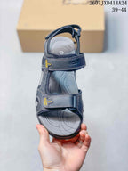Top view of a dark black open-toe sandal showing its adjustable straps, cushioned footbed and printed contour details.