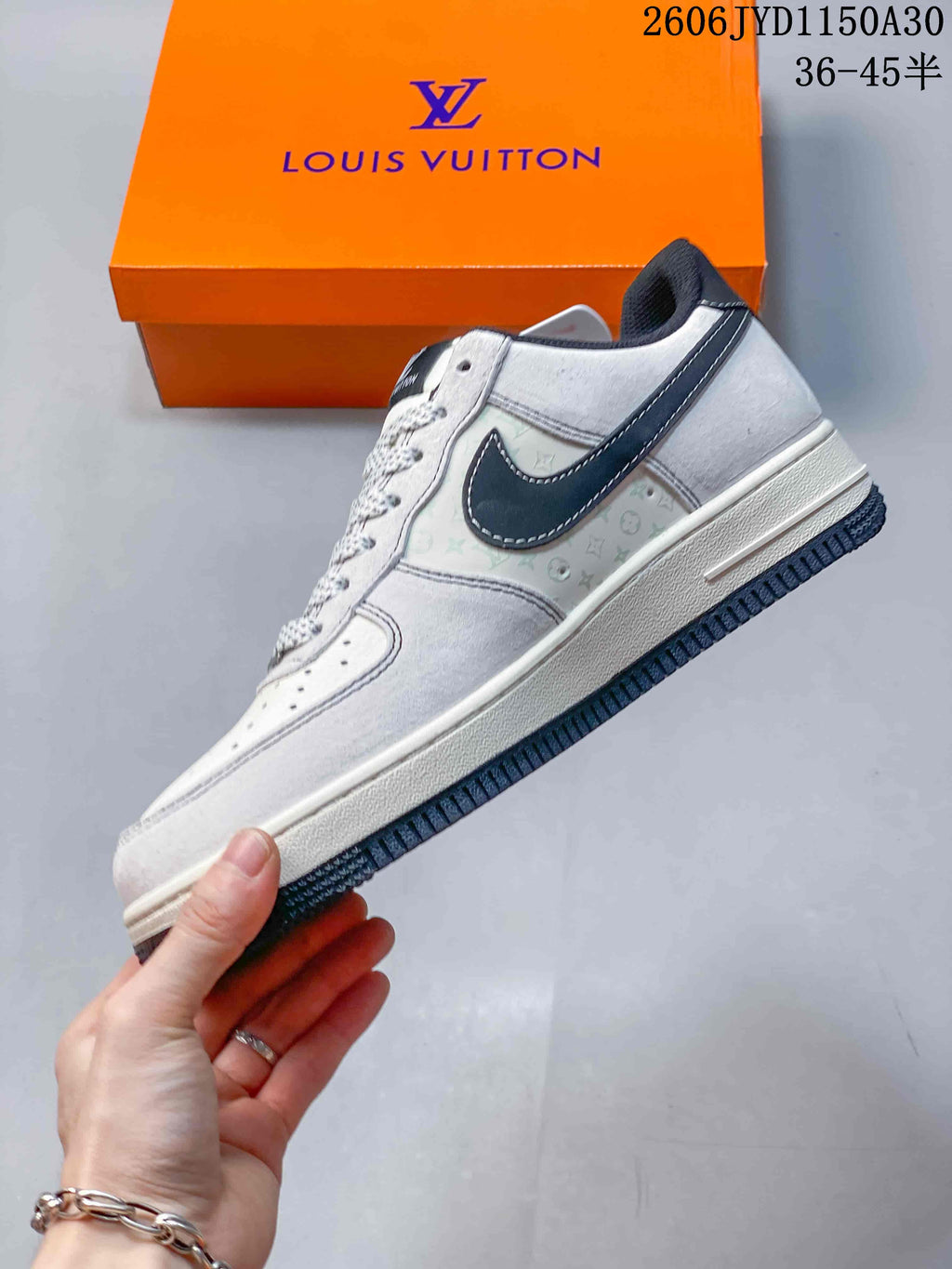 Side view of a white and gray sneaker with a dark swoosh-shaped overlay and patterned side panel