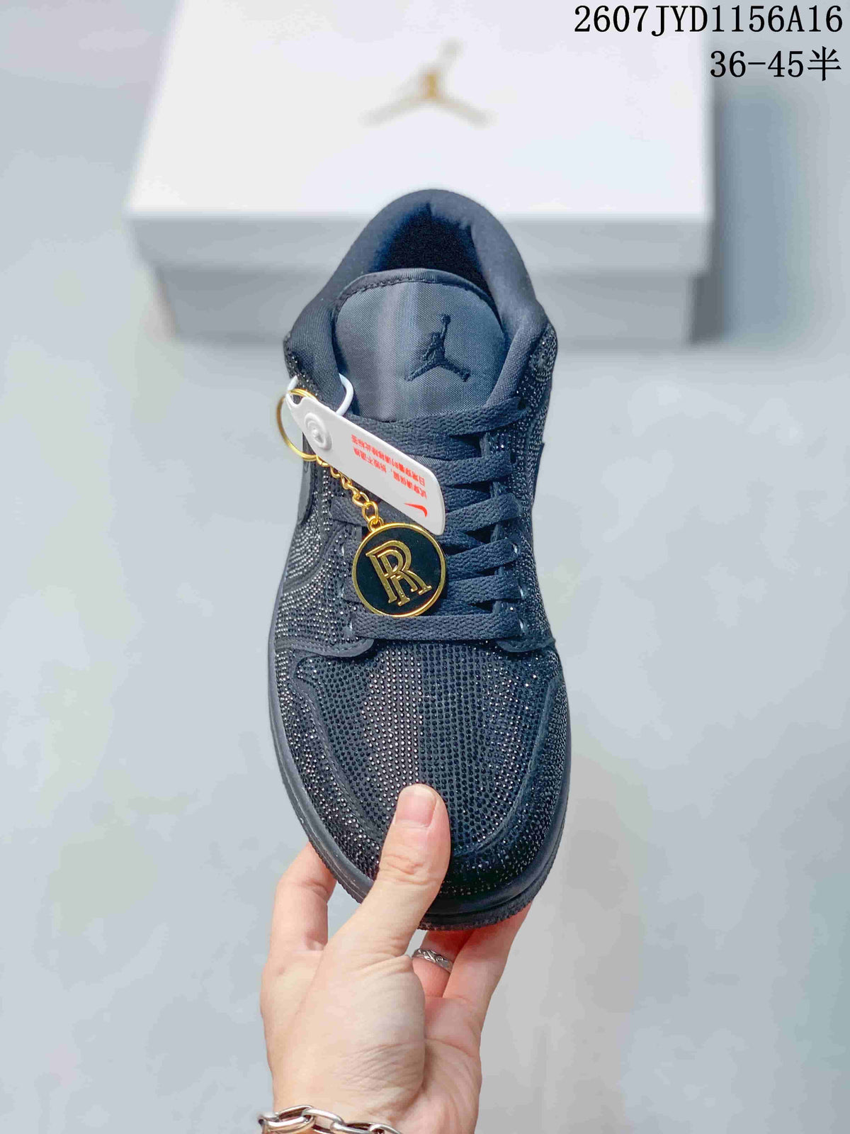 Front view of a black Jordan sneaker showing the embellished toe box, laces, tongue branding and decorative hangtags.