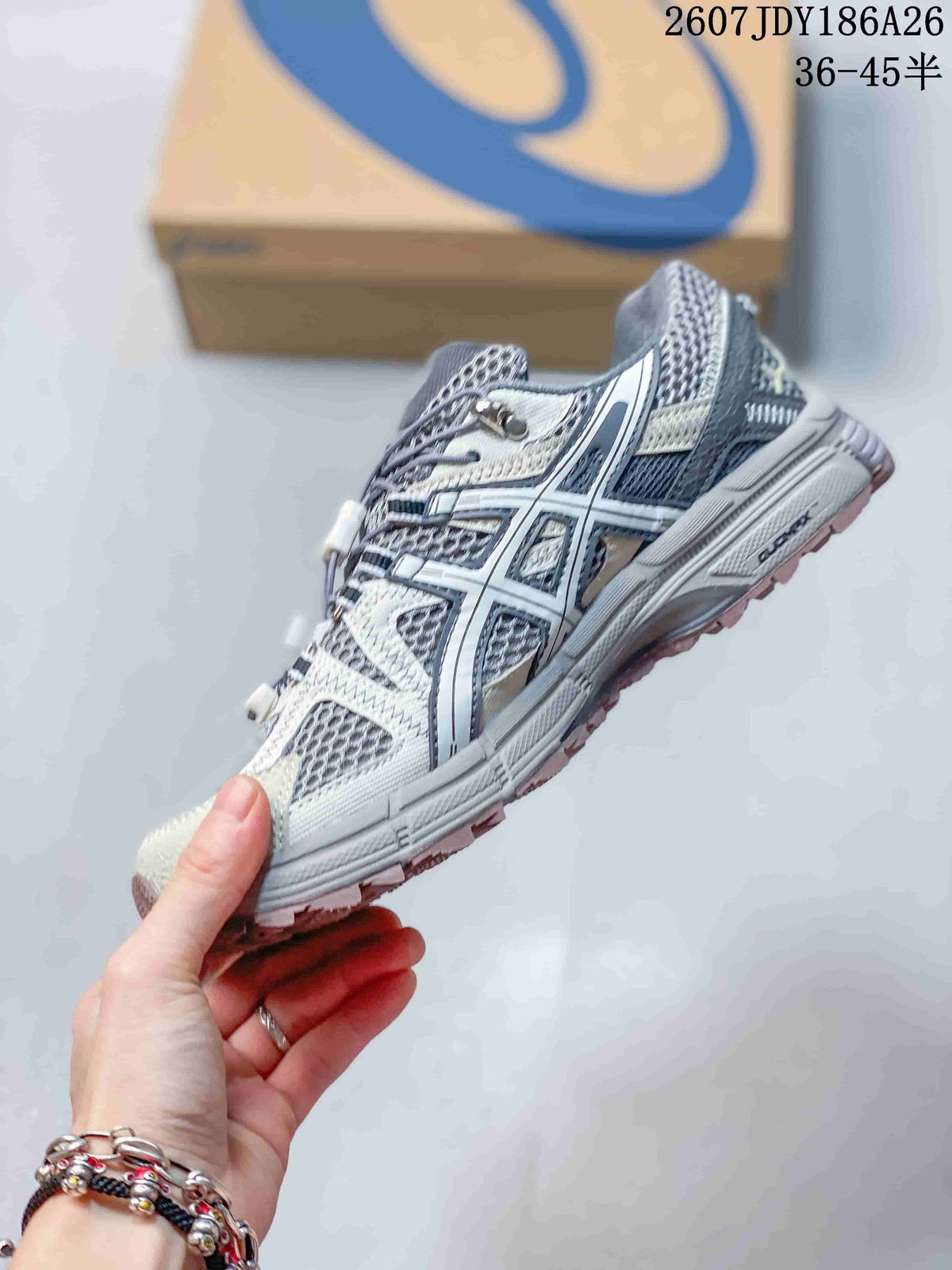 Side profile of the gray and white ASICS Gel-Kahana 8 FL sneaker, showing layered overlays, side branding, mesh-style panels, and a treaded sole.