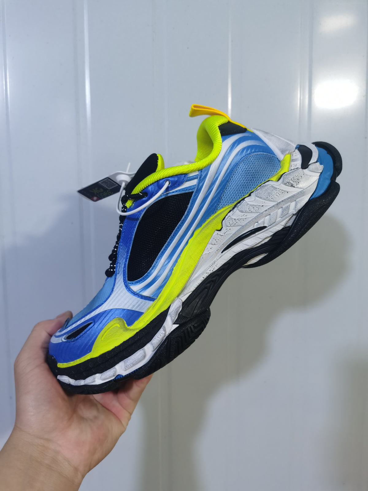 Angled view of the blue, white, black and yellow Balenciaga Triple S 2 sneaker showing the layered upper and outsole.