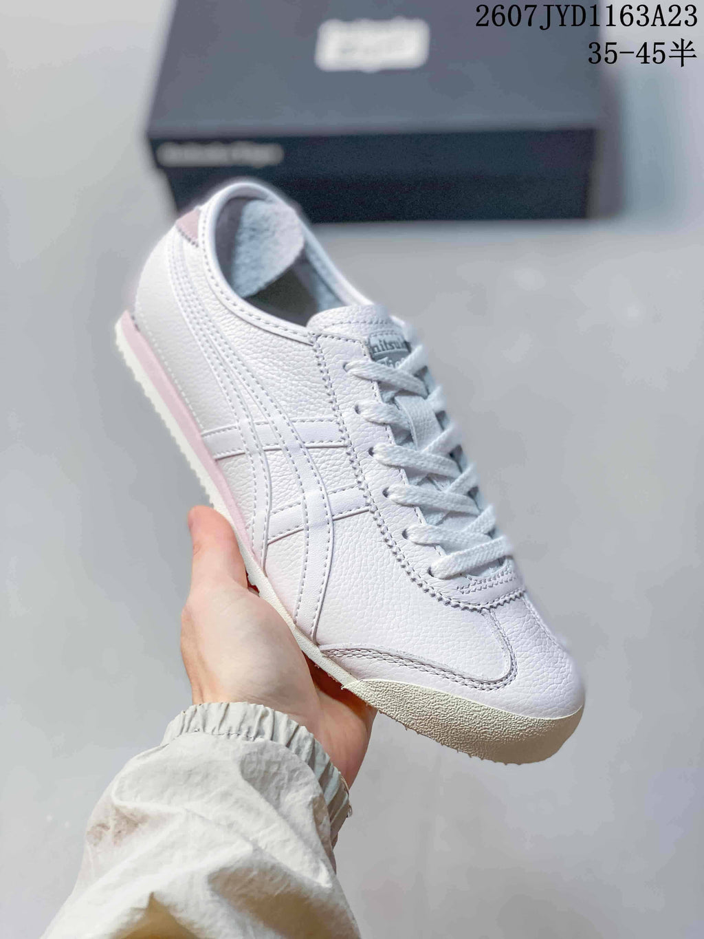Angled side view of the white and pink low-top sneaker with layered side stripes.