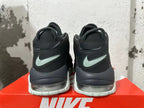 Rear view of black Nike sneakers with pale mint-green heel Swooshes, white outsoles, and visible heel cushioning.