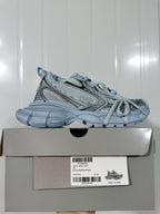 Side profile of the cyan blue sneaker resting on its box; the box label shows W3XL5, color CYAN BLUE and size C 37.