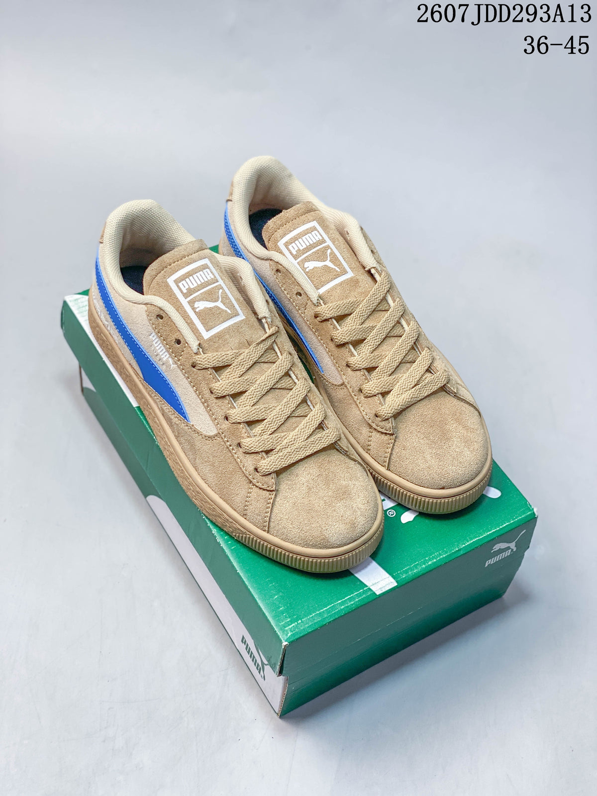Pair of tan and blue PUMA BMW MMS Suede XL sneakers displayed on a green shoebox.