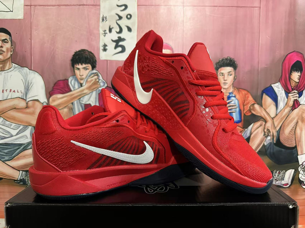 Pair of red Nike basketball shoes showing silver Swoosh accents and dark outsoles.