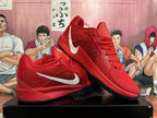 Pair of red Nike basketball shoes showing silver Swoosh accents and dark outsoles.