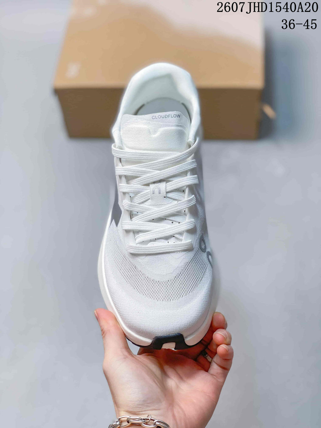 Top view of the white lace-up sneaker showing the mesh-like forefoot, tongue branding, and gray details.