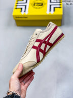 Side view highlighting the cream upper, red Onitsuka Tiger stripes, low-top profile, and textured toe area.